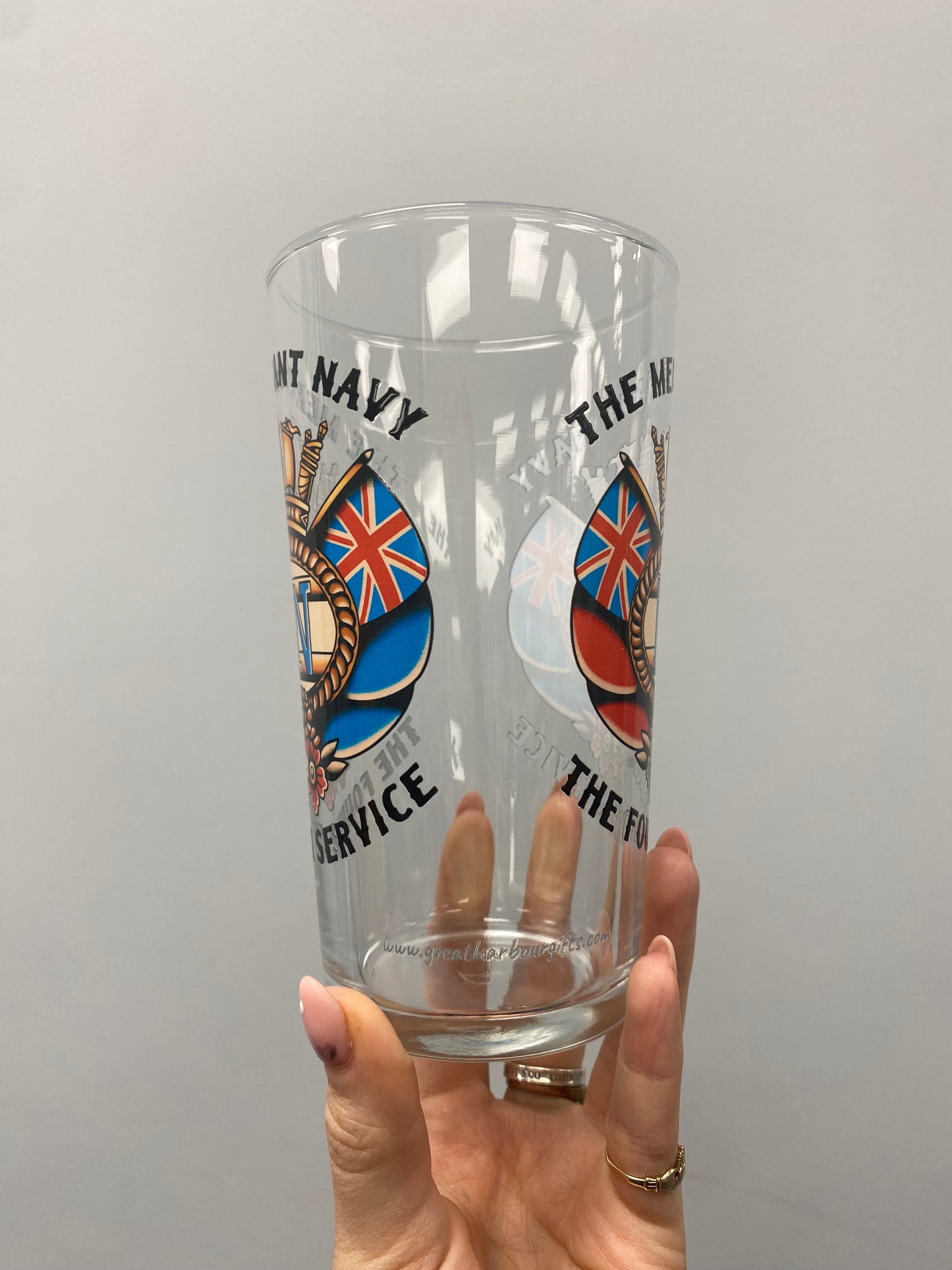 Pint glass, sailor tattoo Merchant Navy badge and swallows